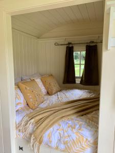 Bett in einem kleinen Zimmer mit Fenster in der Unterkunft Tower Farm Holidays in Llangollen