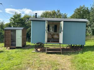 ein blauer Schuppen mit einer Bank auf einem Feld in der Unterkunft Tower Farm Holidays in Llangollen + 58 Fotos