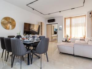 a dining room and living room with a table and a couch at Villa Ivica & Marica by Interhome in Maslenica