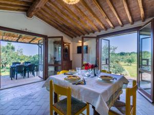 a dining room with a table and chairs and sliding glass doors at Holiday Home Rustico by Interhome in Bibbona