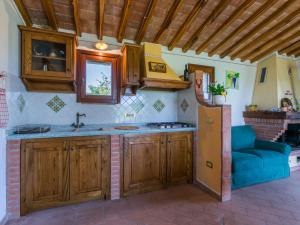 a kitchen with wooden cabinets and a sink and a refrigerator at Holiday Home Rustico by Interhome in Bibbona