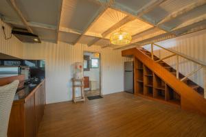 a kitchen with a wooden floor and a staircase in a room at The Sri Loft in Dalung