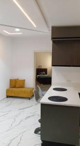 a kitchen with a stove and a living room at Résidence Harmonia Djerba in Houmt Souk