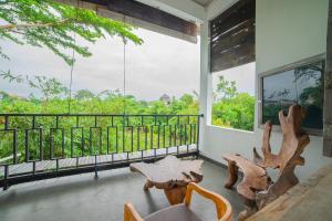 a room with a balcony with a table and chairs at The Sri Loft in Dalung
