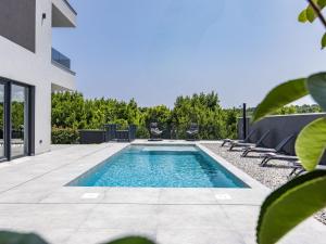 a swimming pool in the middle of a patio with chairs at Villa Delecto by Interhome in Pula