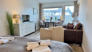 a bedroom with a bed and a living room at Strand-Gut, 12-29 in Westerland (Sylt)