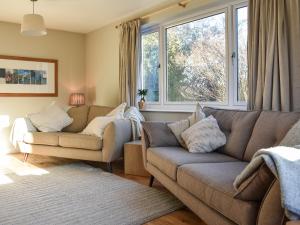 ein Wohnzimmer mit 2 Sofas und einem Fenster in der Unterkunft Nurses Cottage in Askham