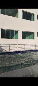 a white building with a lot of windows at Kitnet pé na areia in Praia Grande