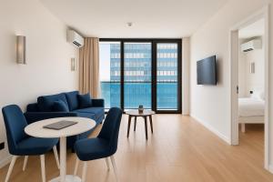 a living room with a blue couch and a table at Blue Side Orbi City in Batumi