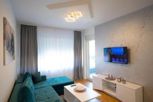a living room with a blue couch and a window at Apartman Petra Trebinje in Trebinje