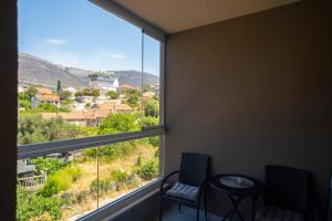 a room with a large window with two chairs and a table at Apartman Petra Trebinje in Trebinje