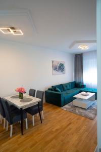 a living room with a blue couch and a table at Apartman Petra Trebinje in Trebinje