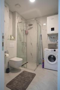 a bathroom with a shower toilet and a washing machine at Apartman Petra Trebinje in Trebinje +68 photos