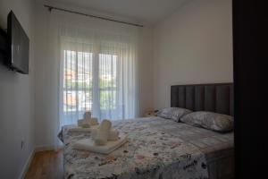 a bedroom with a bed with two chairs on it at Apartman Petra Trebinje in Trebinje