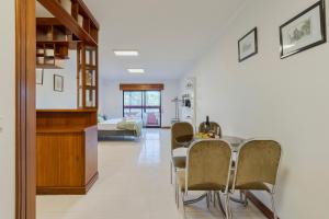 a dining room and living room with a table and chairs at Regina Beach House - By Y Concept in Costa da Caparica