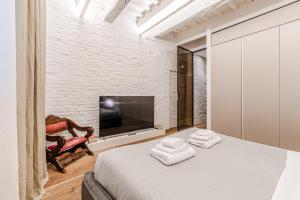 a bedroom with a large bed and a tv at Casa Sapienza - Luxury Apartment in the Centre in Siena