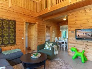 un salon avec un canapé et une télévision dans une cabane en rondins dans l'établissement Holiday Home Susi by Interhome, à Savonranta