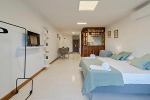 a hotel room with two beds and a kitchen at Regina Beach House - By Y Concept in Costa da Caparica