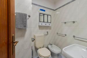 a white bathroom with a toilet and a sink at Regina Beach House - By Y Concept in Costa da Caparica +15 photos