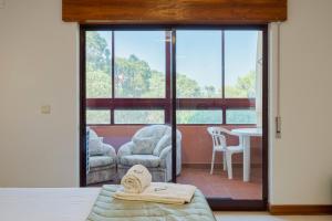 a room with a bed and a chair and a table at Regina Beach House - By Y Concept in Costa da Caparica