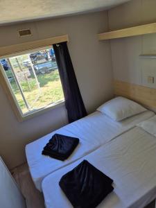 Postel nebo postele na pokoji v ubytování Le mobile home est dans le pré + 2 fotografie