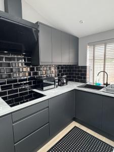 a kitchen with black and white appliances and a sink at Ravenscourt Rooms by Brabazon Rooms in Bristol