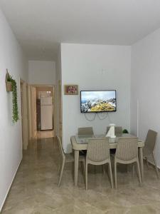 a dining room with a table and chairs and a tv on the wall at Casa del Mar Rafraf in Rafrāf +24 photos