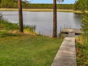 a wooden boardwalk next to a lake with trees at Holiday Home Paloniemi by Interhome in Savitaipale