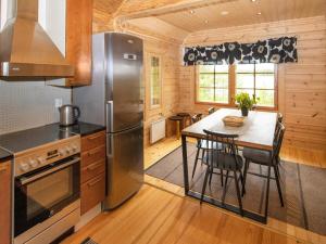 a kitchen with a table and a stainless steel refrigerator at Holiday Home Paloniemi by Interhome in Savitaipale +21 photos