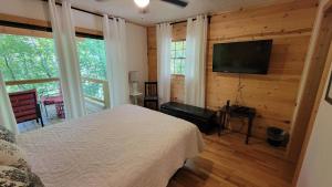 a bedroom with a bed and a flat screen tv at Hickory Ridge - HotTub - GSMNP, NOC, Train and Fontana Lake in Almond