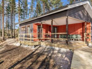 uma pequena casa na floresta com um deque em Holiday Home Järven idylli by Interhome em Virmutjoki