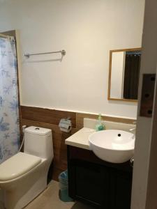 a bathroom with a white toilet and a sink at Cozy 2bedrooms Matina Enclaves condo in Davao City