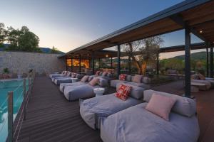 a row of couches on a deck next to a pool at Campoblù in Marina di Campo