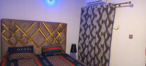 a bed with a head board and a curtain at Spacious One bedroom serviced apartment with Wifi Smart TV Air conditioning kitchen and other facilities in a cozy living space in Lagos