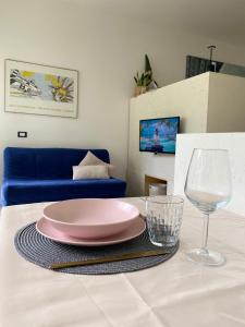 a table with a pink plate and a glass at LAC Holiday Apartment in Calceranica al Lago