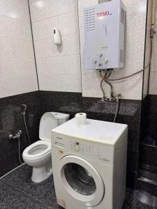 une salle de bain avec machine à laver et toilettes dans l'établissement Vikings Home Nizami Street, à Baku 6 autres photos