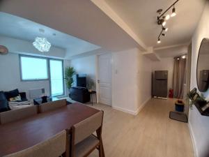 a living room with a couch and a table at Family Room 1BR HUGE Balcony in Azure North in San Fernando