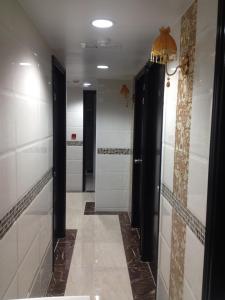 baño con puertas negras y paredes de azulejos blancos en Manhattan Guesthouse, en Hong Kong