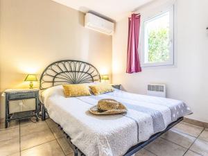 a bedroom with a bed with a hat on it at Holiday Home Hacienda Beach II-7 by Interhome in Agde