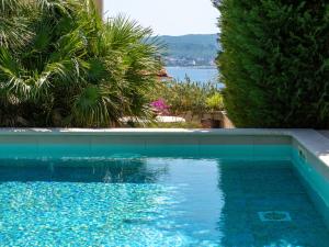 a blue swimming pool with a view of the water at Apartment Dita-1 by Interhome in Crikvenica