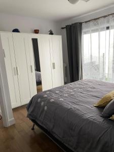 a bedroom with a bed and white cabinets and a window at L Appart du St-Laurent 2e in Lévis