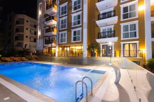 a swimming pool in front of a building at night at Hotel 6 Marsi in Golem