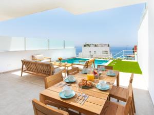 a dining room with a table and a view of the ocean at Apartment D'Mediterranea private pool & sauna by Interhome in Torrox Costa