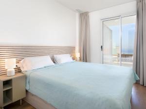 a white bedroom with a large bed and a window at Apartment D'Mediterranea private pool & sauna by Interhome in Torrox Costa