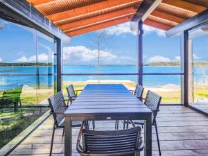 a table and chairs on a deck with a view of the water at Holiday Home Villa haave by Interhome in Kustavi