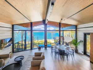 a living room with a table and chairs and large windows at Holiday Home Villa haave by Interhome in Kustavi
