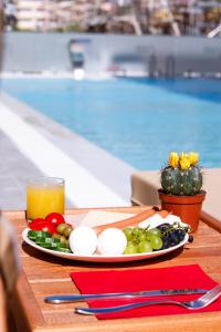 a plate of vegetables on a table next to a pool at Hotel 6 Marsi in Golem