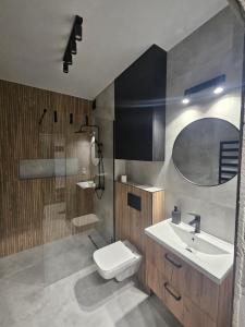 ein Badezimmer mit Waschbecken, Toilette und Dusche in der Unterkunft Apart Family Lębork in Lębork