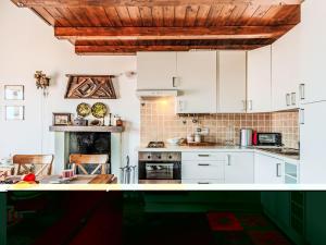 a kitchen with white cabinets and a fireplace at Apartment Laghina by Interhome in Musso