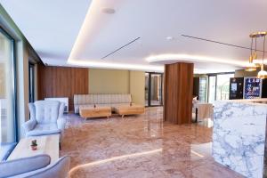 a living room with blue chairs and a couch at Hotel 6 Marsi in Golem